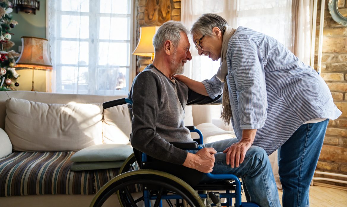 Government funded personal alarm - elderly couple with mature man in wheelchair