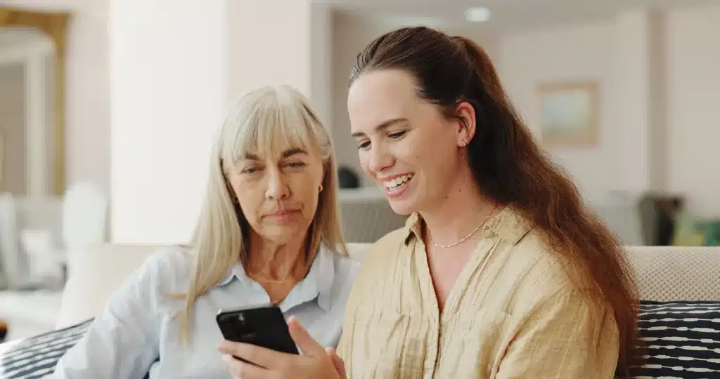 Caregiver checking a health watch app to monitor an elderly loved one