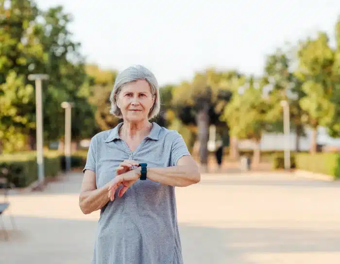 Senior wearing a SureSafeGO health watch while walking outdoors
